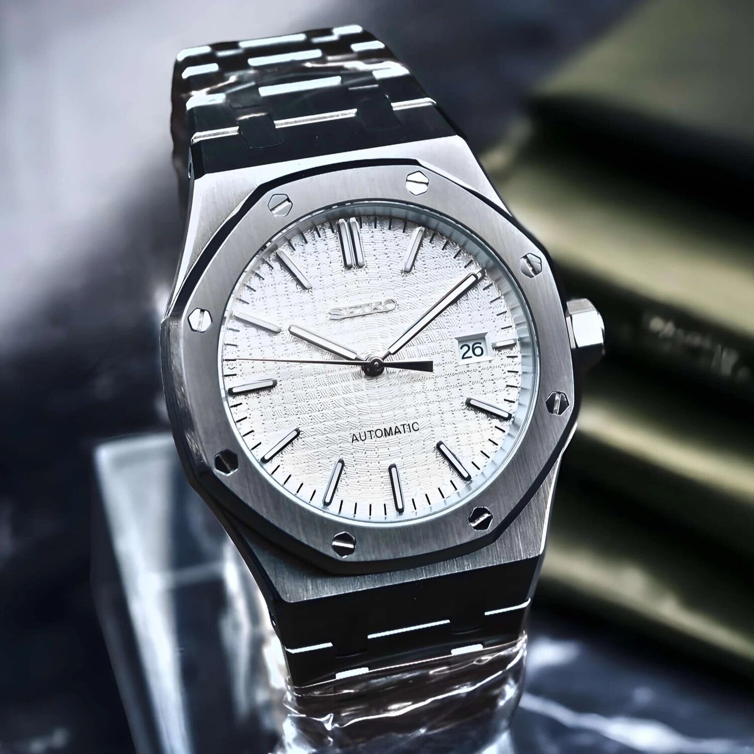 Right angled view of Seiko Mod Royal Oak in brushed stainless steel, featuring a textured white dial with date window and slim baton indices.